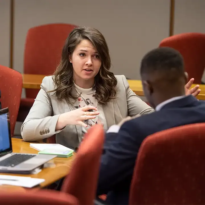 Man and woman in business attire sitting and talking